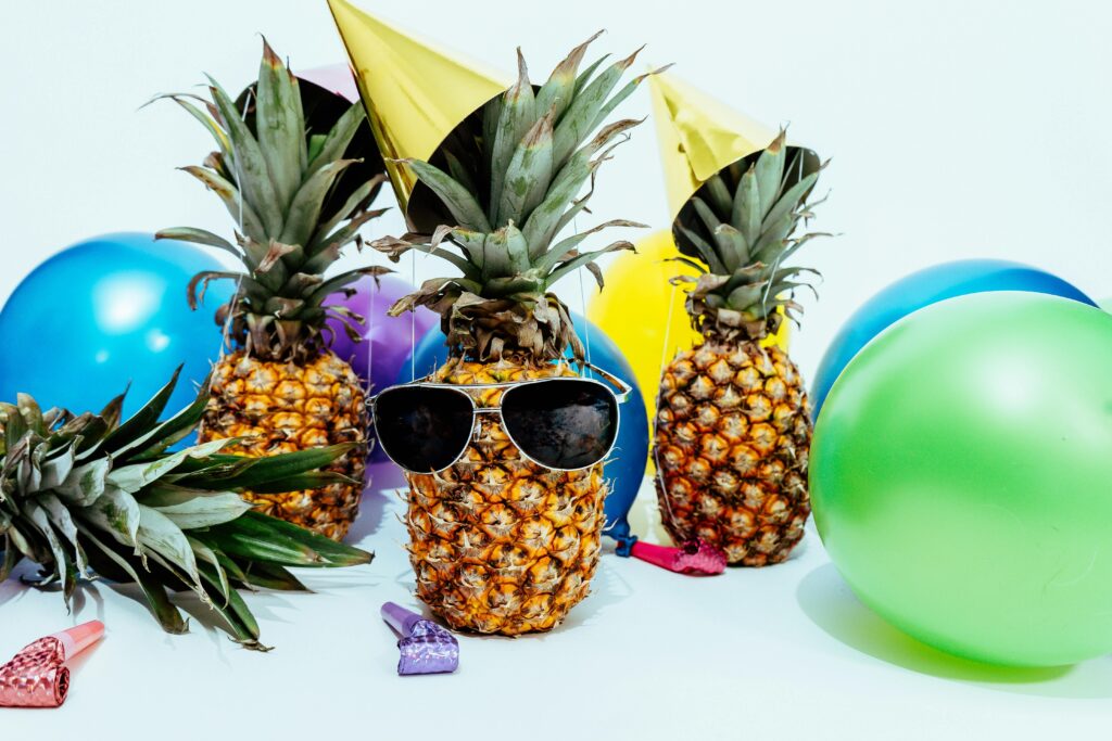 Fun tropical-themed party featuring pineapples with sunglasses and colorful balloons.