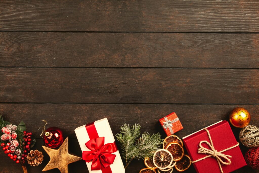 Festive Christmas gifts and decorations on rustic wood background perfect for holiday themes.