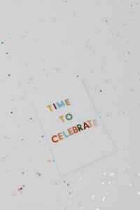 Vibrant 'Time to Celebrate' greeting card surrounded by confetti.