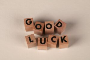 Wooden blocks with letters spell 'Good Luck' on a beige background, signifying encouragement and support.